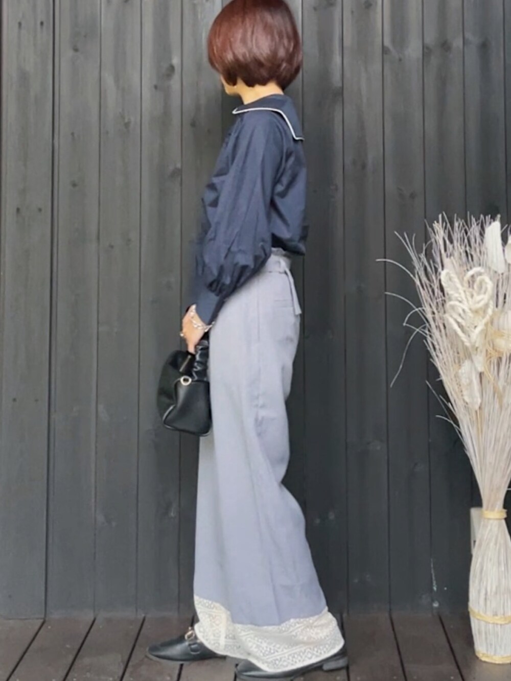 ブルー系のシャツ/ブラウス、グレー系のその他パンツ、ブラック系のハンドバッグを着用したレディースの春コーディネートの2枚目の写真