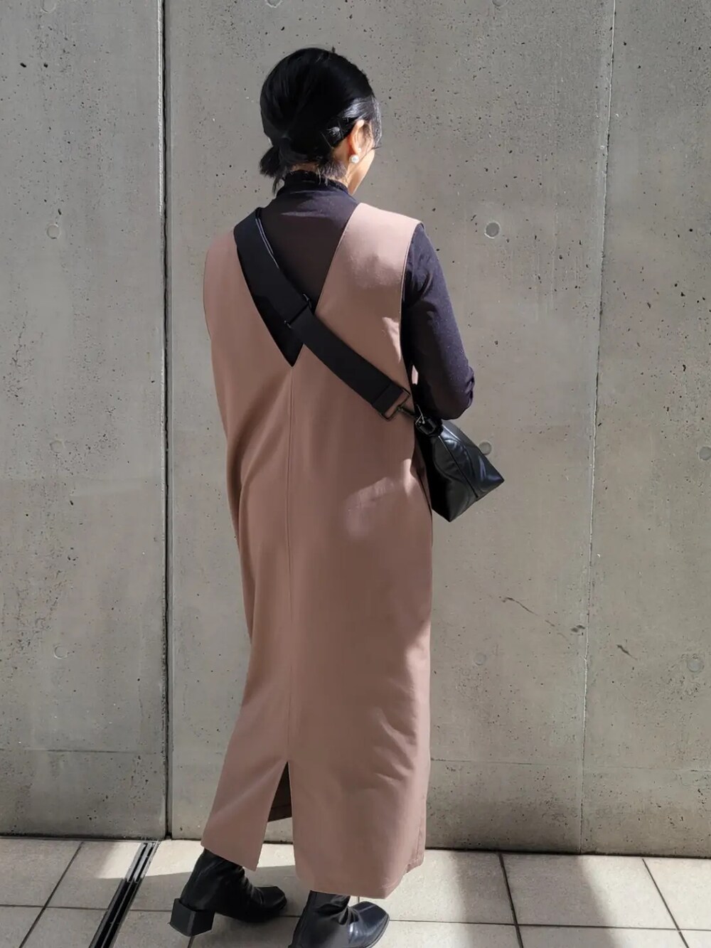 ブラック系のショルダーバッグ、ブラウン系のジャンパースカート、ブラック系のTシャツ/カットソーを着用したレディースの秋コーディネートの2枚目の写真