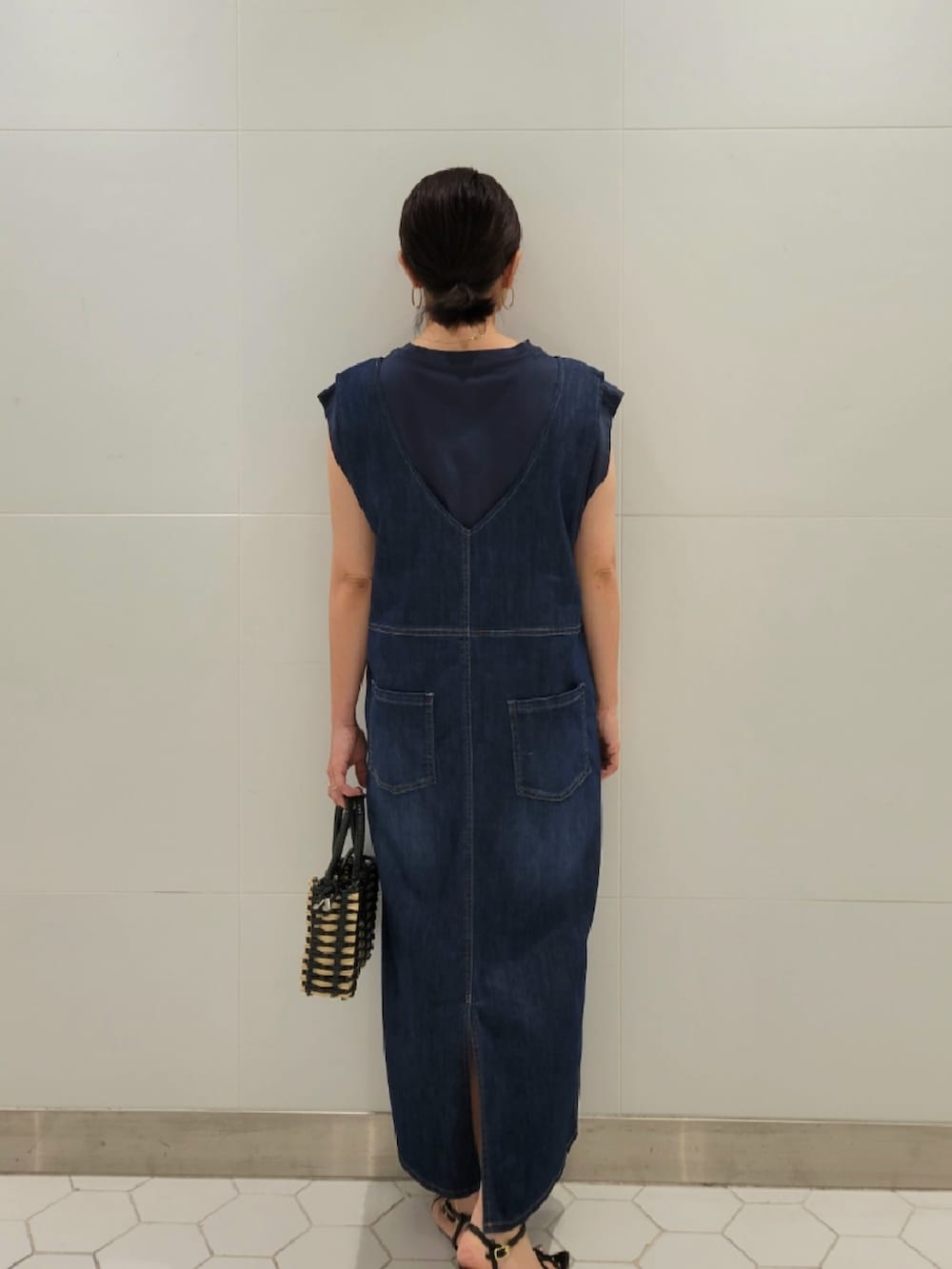 ブラック系のショルダーバッグ、ブルー系のジャンパースカート、ブルー系のTシャツ/カットソーを着用したレディースの夏コーディネートの3枚目の写真