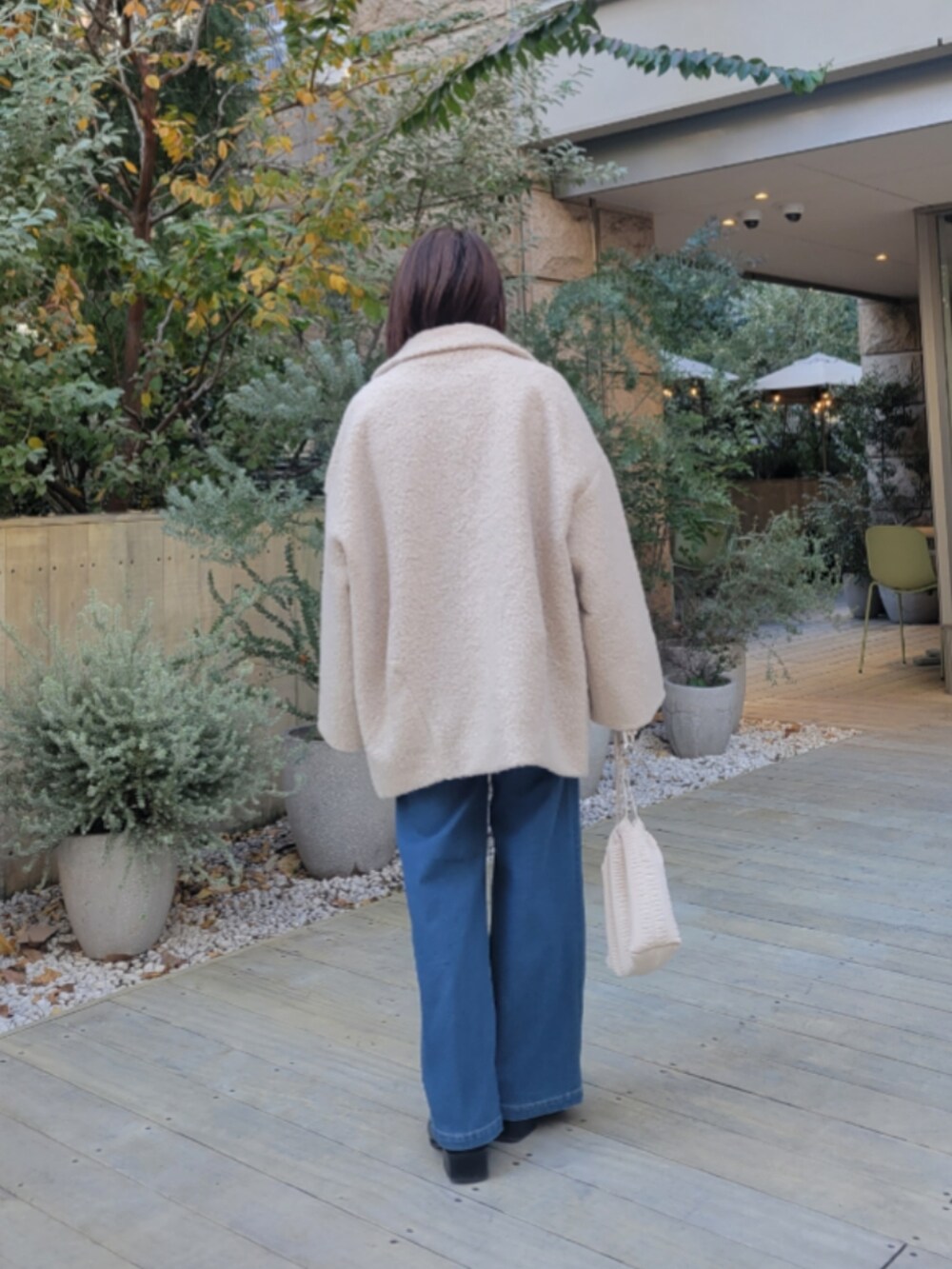 ブルー系のデニムパンツ、ブルー系のニット/セーター、ベージュ系のその他アウターを着用したレディースの冬コーディネートの3枚目の写真
