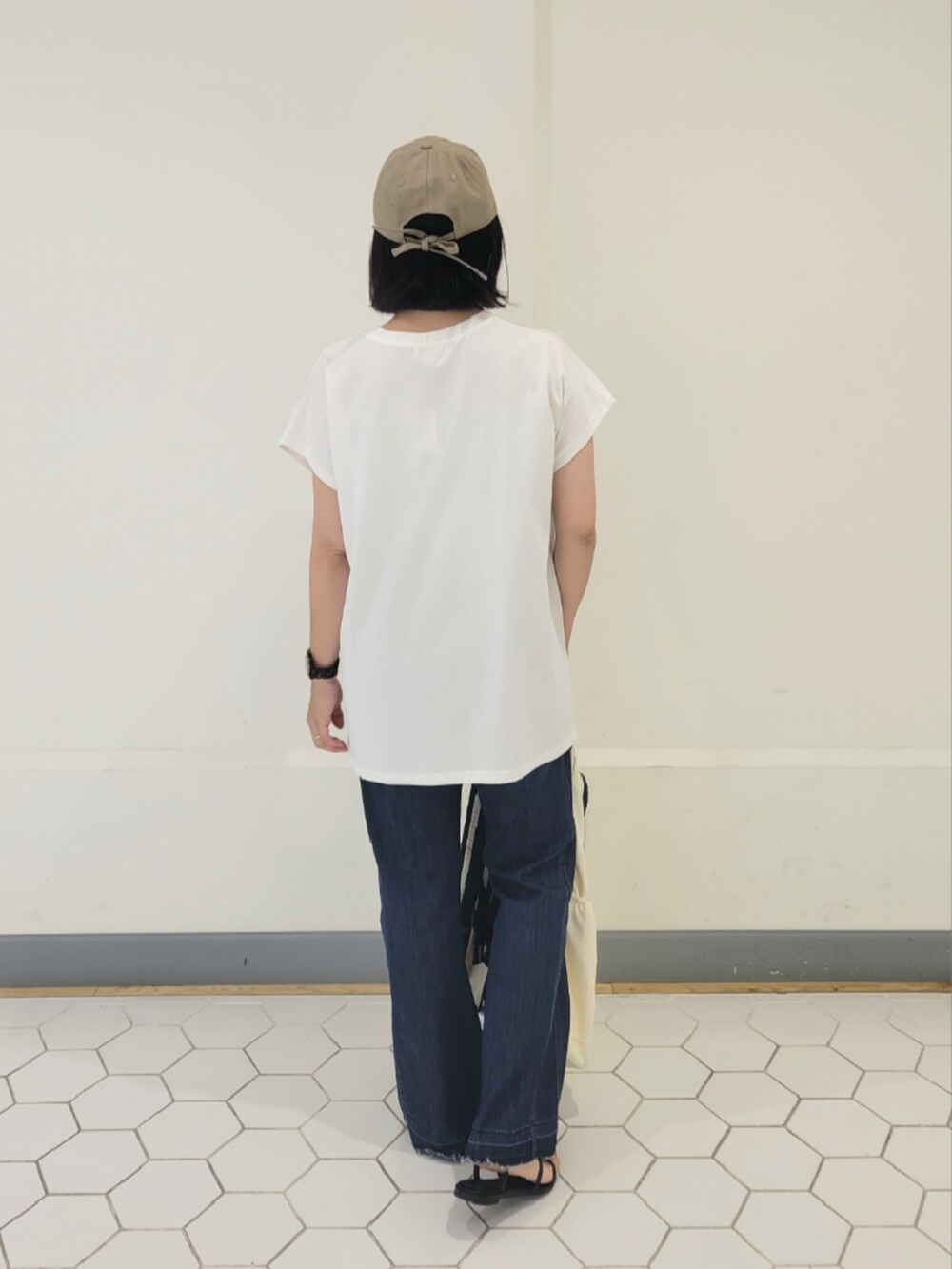 ホワイト系のTシャツ/カットソー、ブルー系のデニムパンツ、ベージュ系のキャップを着用したレディースの夏コーディネートの3枚目の写真