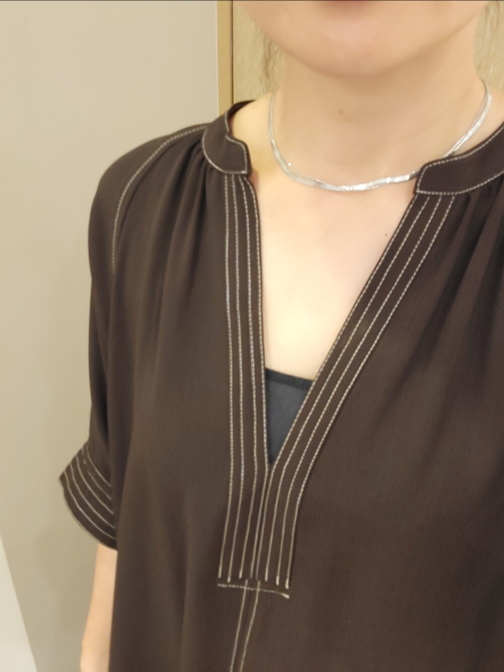 シルバー系のシューズ、ブラウン系のワンピース、ホワイト系のショルダーバッグを着用したレディースの春コーディネートの4枚目の写真