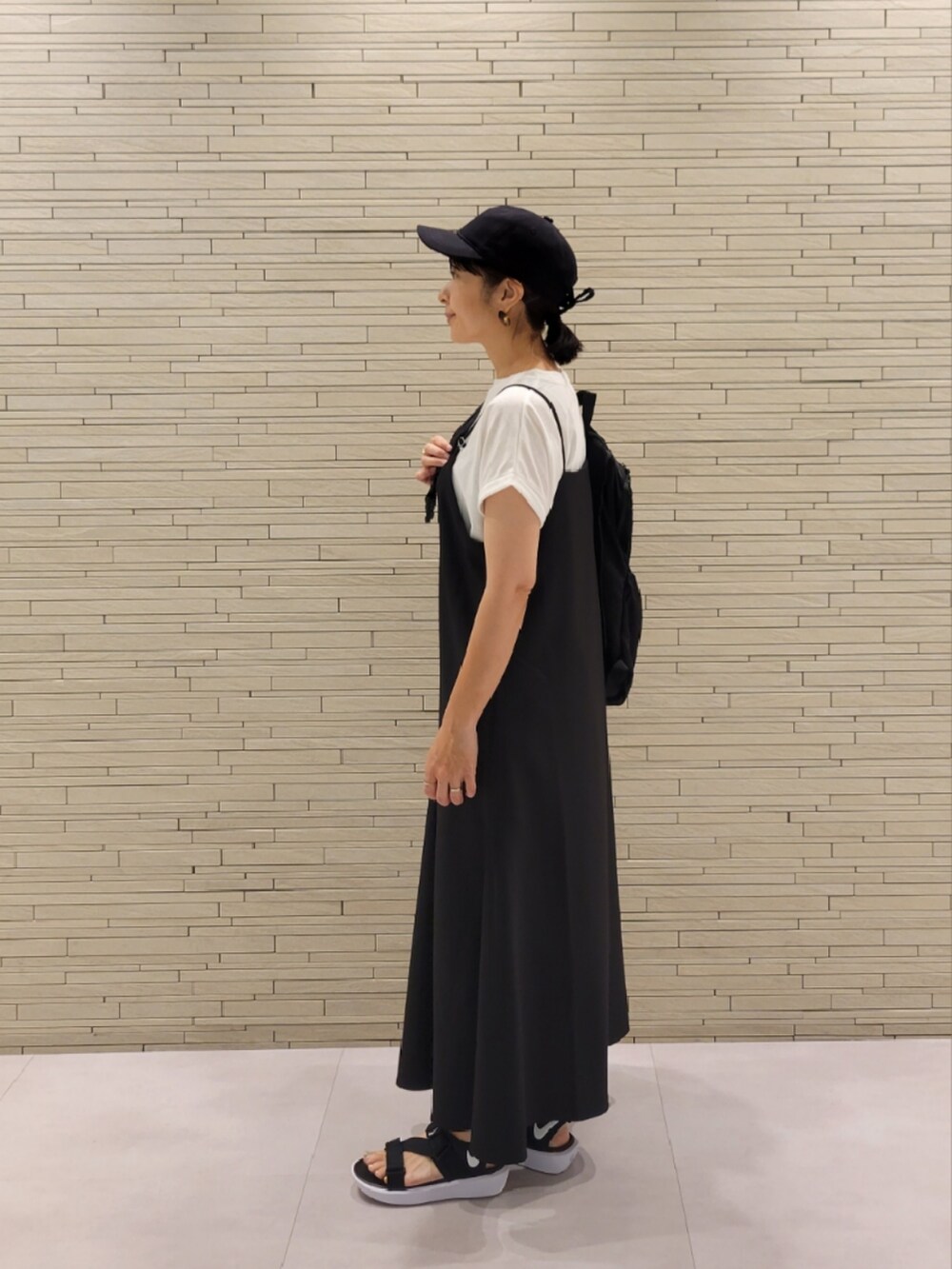 ブラック系のワンピース、ホワイト系のTシャツ/カットソーを着用したレディースの夏コーディネートの2枚目の写真