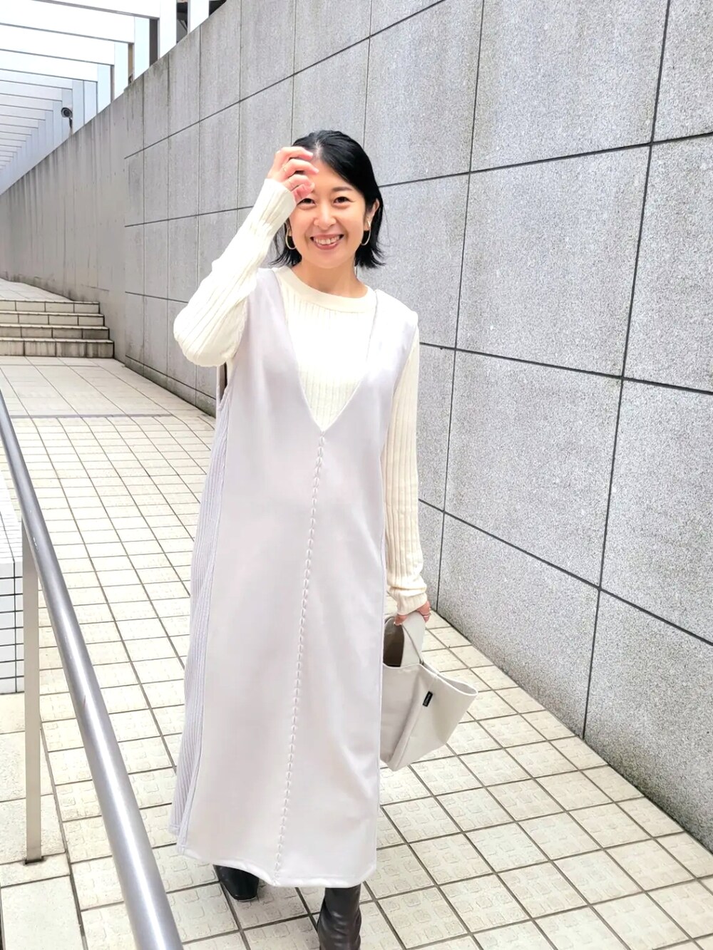 ベージュ系のワンピース、ホワイト系のニット/セーターを着用したレディースの秋コーディネートの3枚目の写真