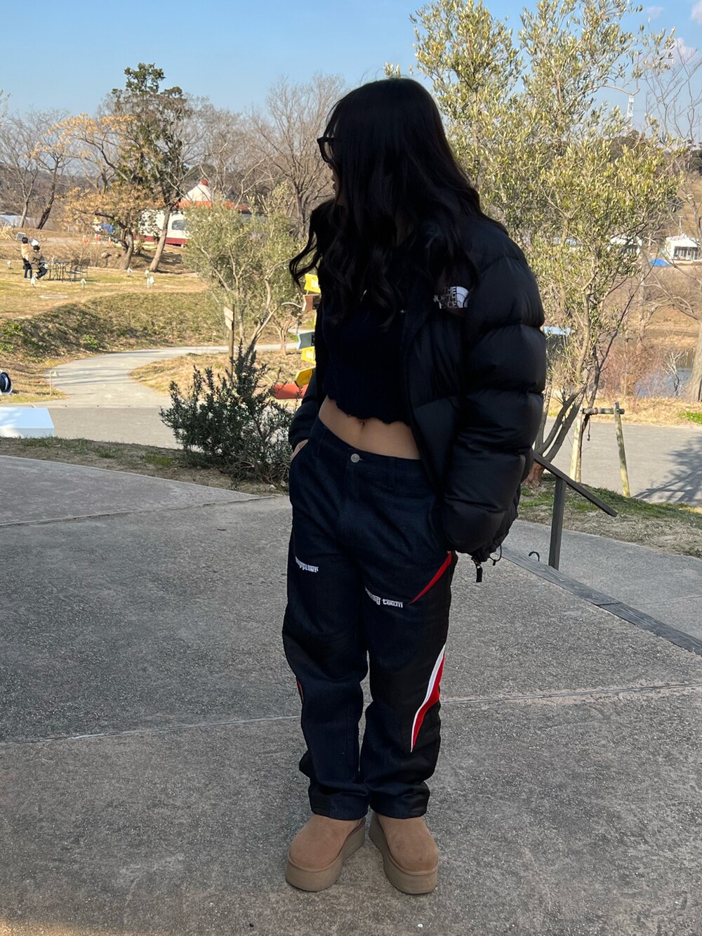 ブラウン系のブーツ、ブラック系のパンツ、ブラック系のダウンジャケット/コートを着用したレディースの冬コーディネートの2枚目の写真