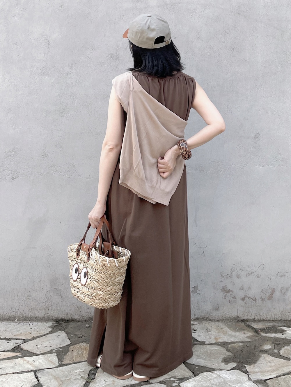 ブラウン系のワンピース、ベージュ系のかごバッグ、ホワイト系のサンダルを着用したレディースの夏コーディネートの3枚目の写真