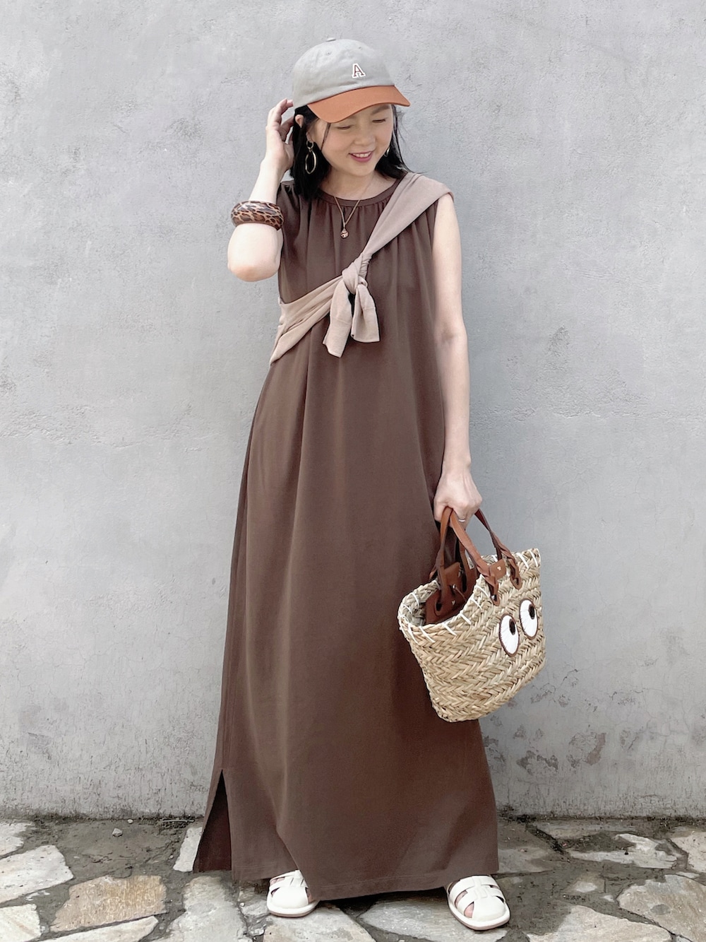 ブラウン系のワンピース、ベージュ系のかごバッグ、ホワイト系のサンダルを着用したレディースの夏コーディネートの2枚目の写真