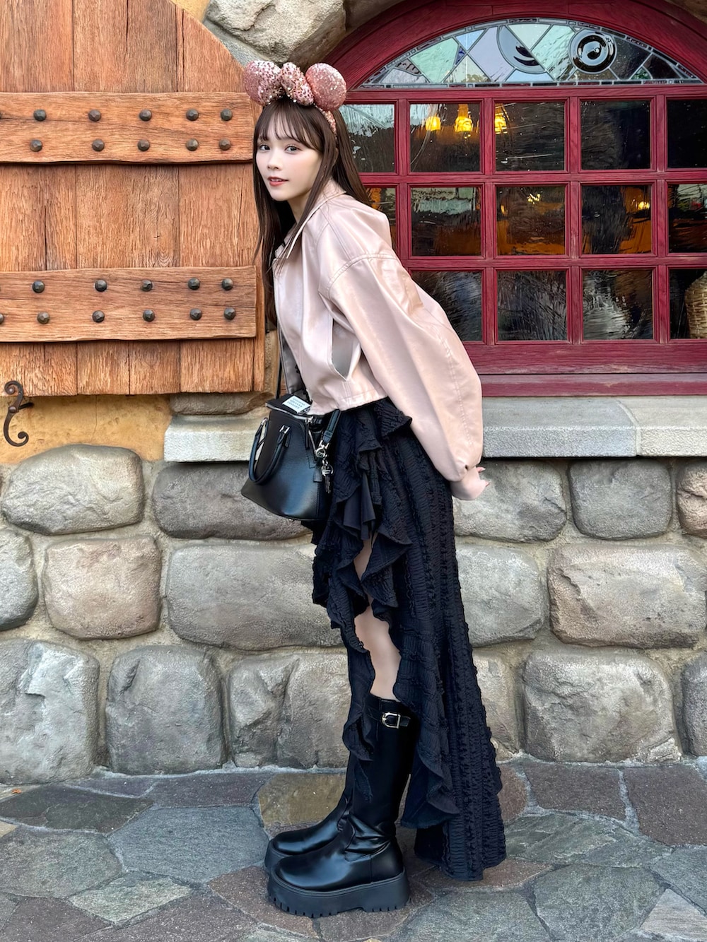 ピンク系のブルゾン、ブラック系のワンピース、ブラック系のショルダーバッグを着用したレディースの春コーディネートの3枚目の写真