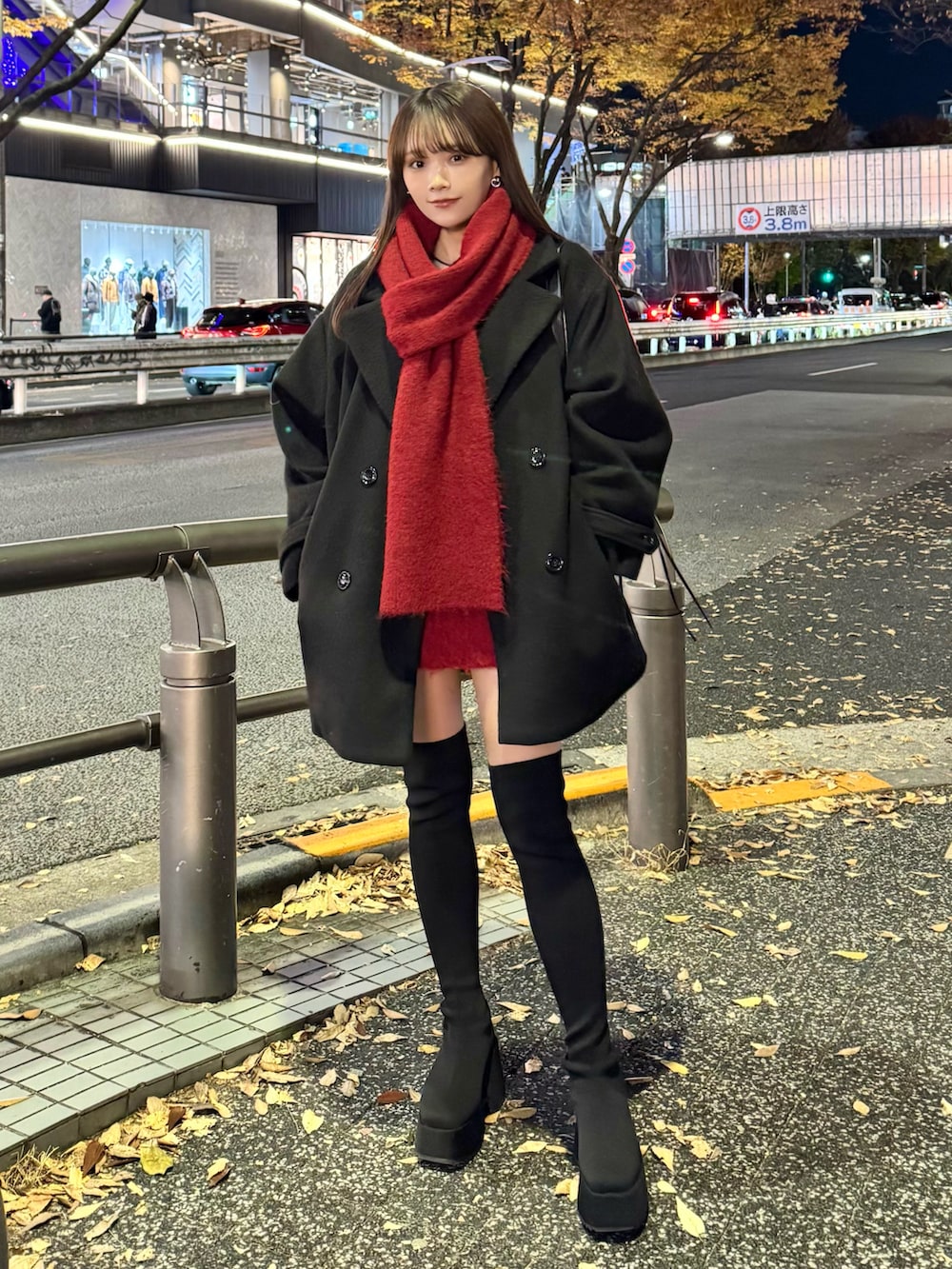 レッド系のワンピース、ブラック系のブーツ、ブラック系のバッグを着用したレディースの冬コーディネートの2枚目の写真