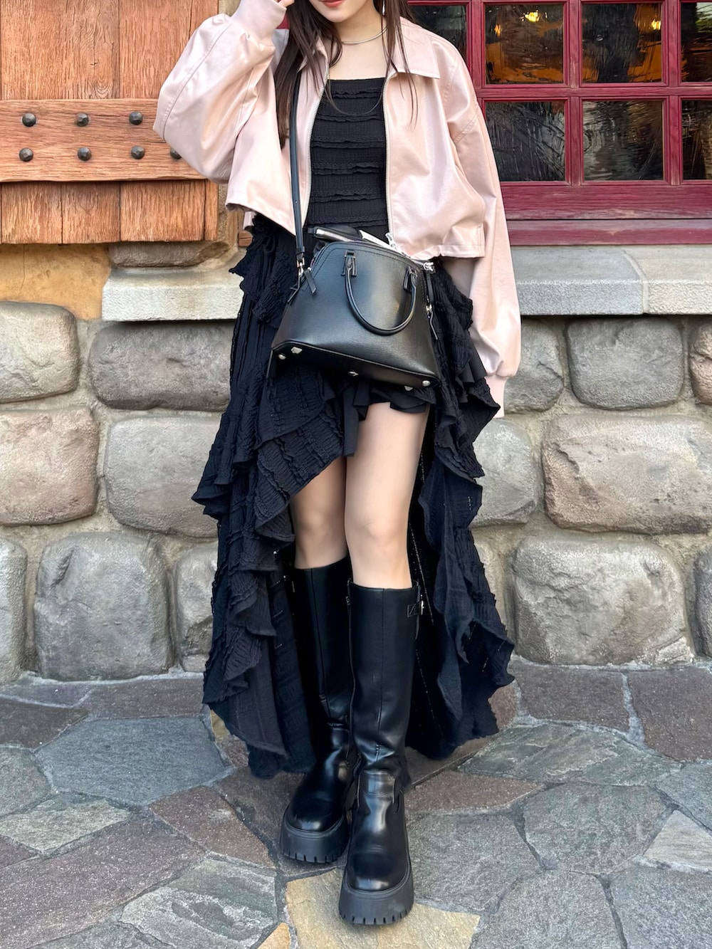 ピンク系のブルゾン、ブラック系のワンピース、ブラック系のショルダーバッグを着用したレディースの春コーディネートの5枚目の写真