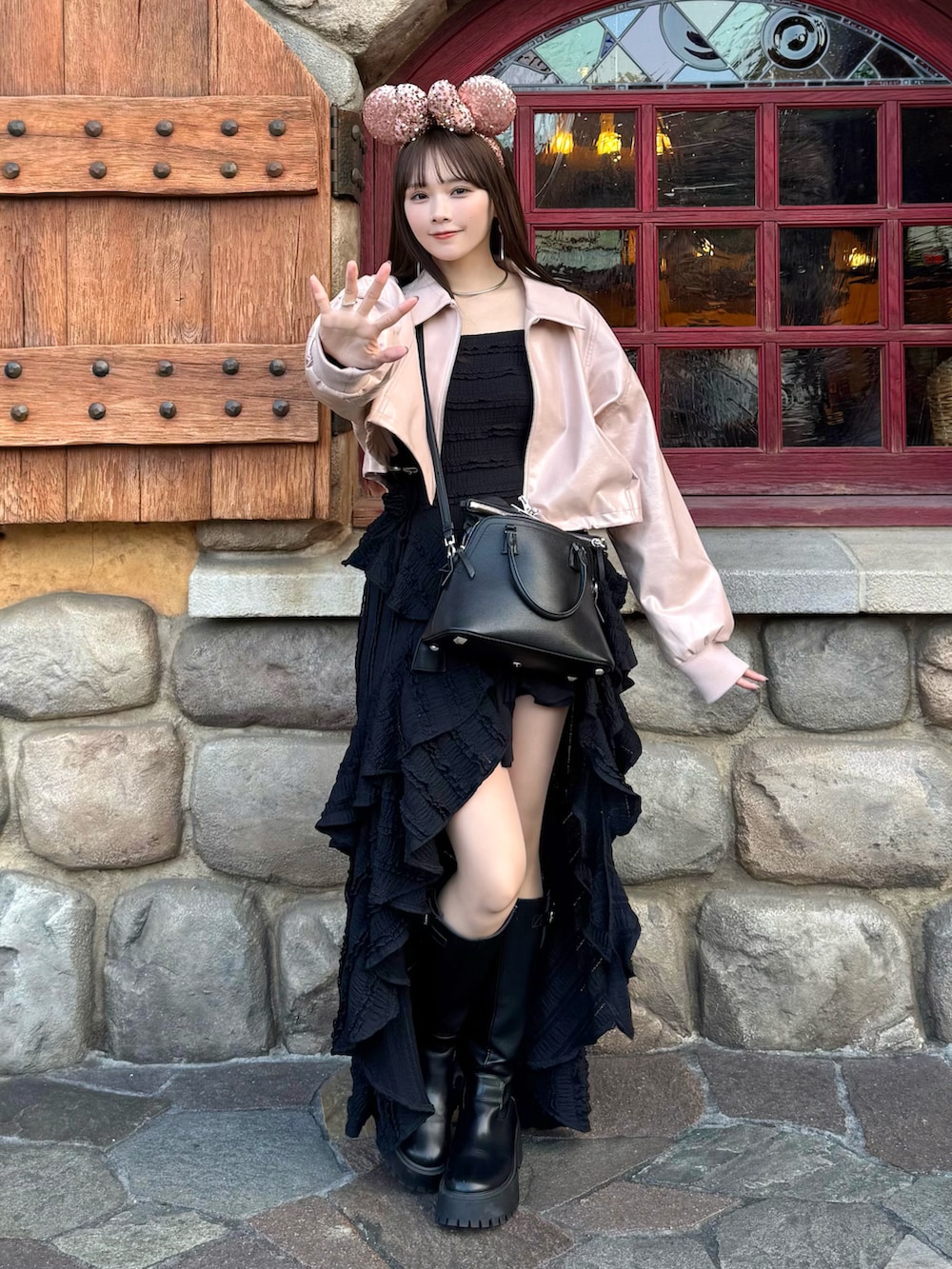 ピンク系のブルゾン、ブラック系のワンピース、ブラック系のショルダーバッグを着用したレディースの春コーディネートの2枚目の写真