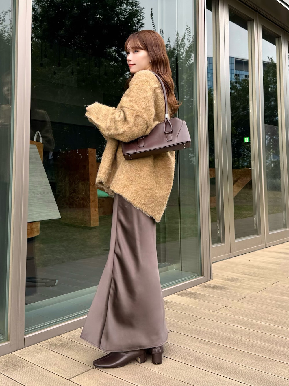 ベージュ系のカーディガン/ボレロ、レッド系のハンドバッグ、ブラウン系のスカートを着用したレディースの冬コーディネートの2枚目の写真