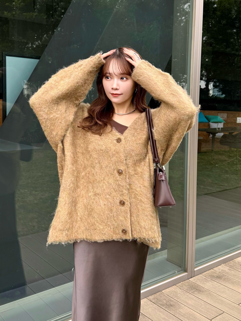 ベージュ系のカーディガン/ボレロ、レッド系のハンドバッグ、ブラウン系のスカートを着用したレディースの冬コーディネートの3枚目の写真