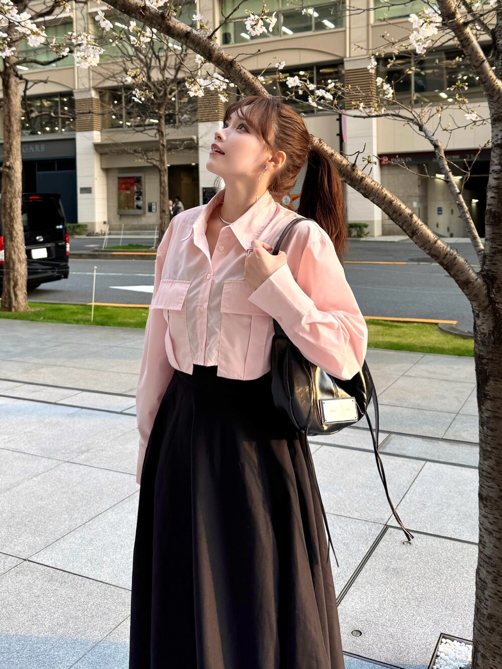 ブラック系のスカート、ピンク系のトップス、ブラック系のローファーを着用したレディースの春コーディネートの4枚目の写真