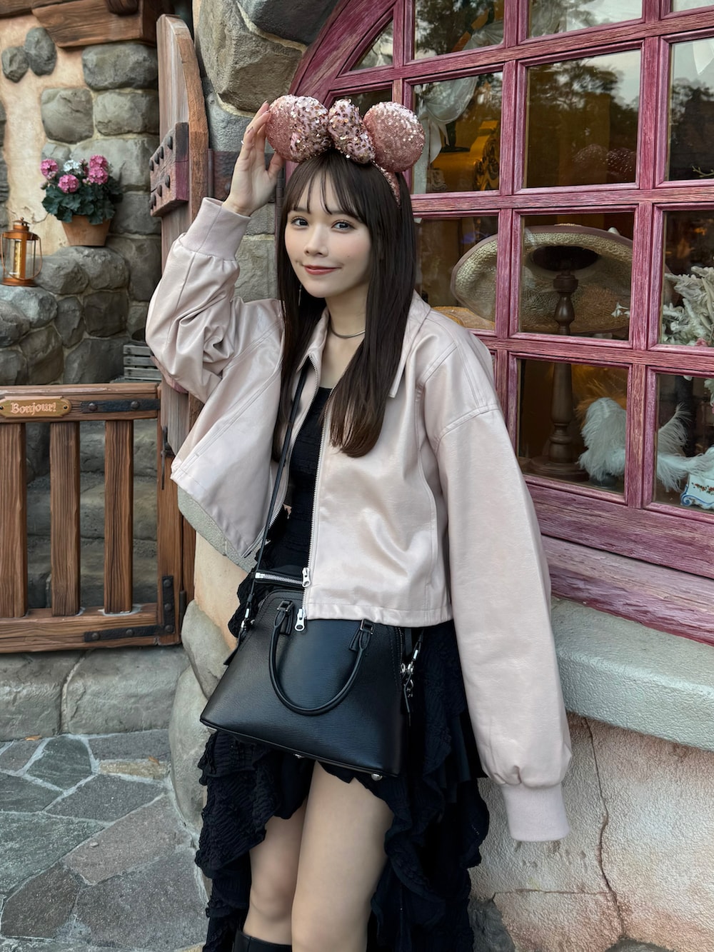 ピンク系のブルゾン、ブラック系のワンピース、ブラック系のショルダーバッグを着用したレディースの春コーディネートの4枚目の写真