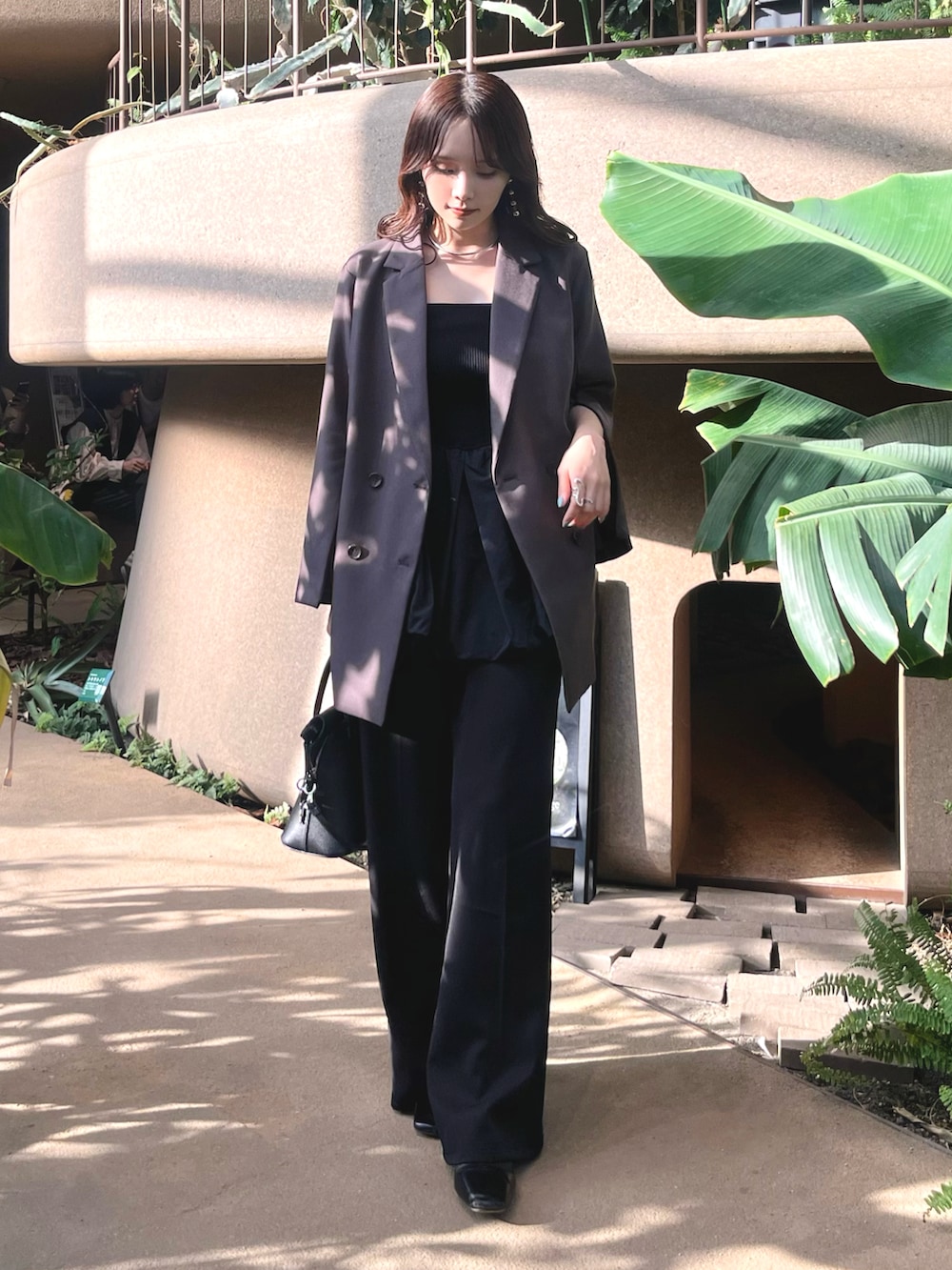 グレー系のテーラードジャケット、ブラック系のキャミソール、ブラック系のショルダーバッグを着用したレディースの春コーディネートの3枚目の写真