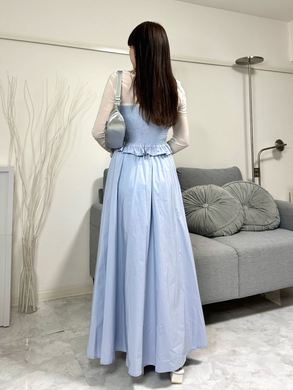 ブルー系のスカート、シルバー系のショルダーバッグ、ホワイト系のトップスを着用したレディースの春コーディネートの3枚目の写真