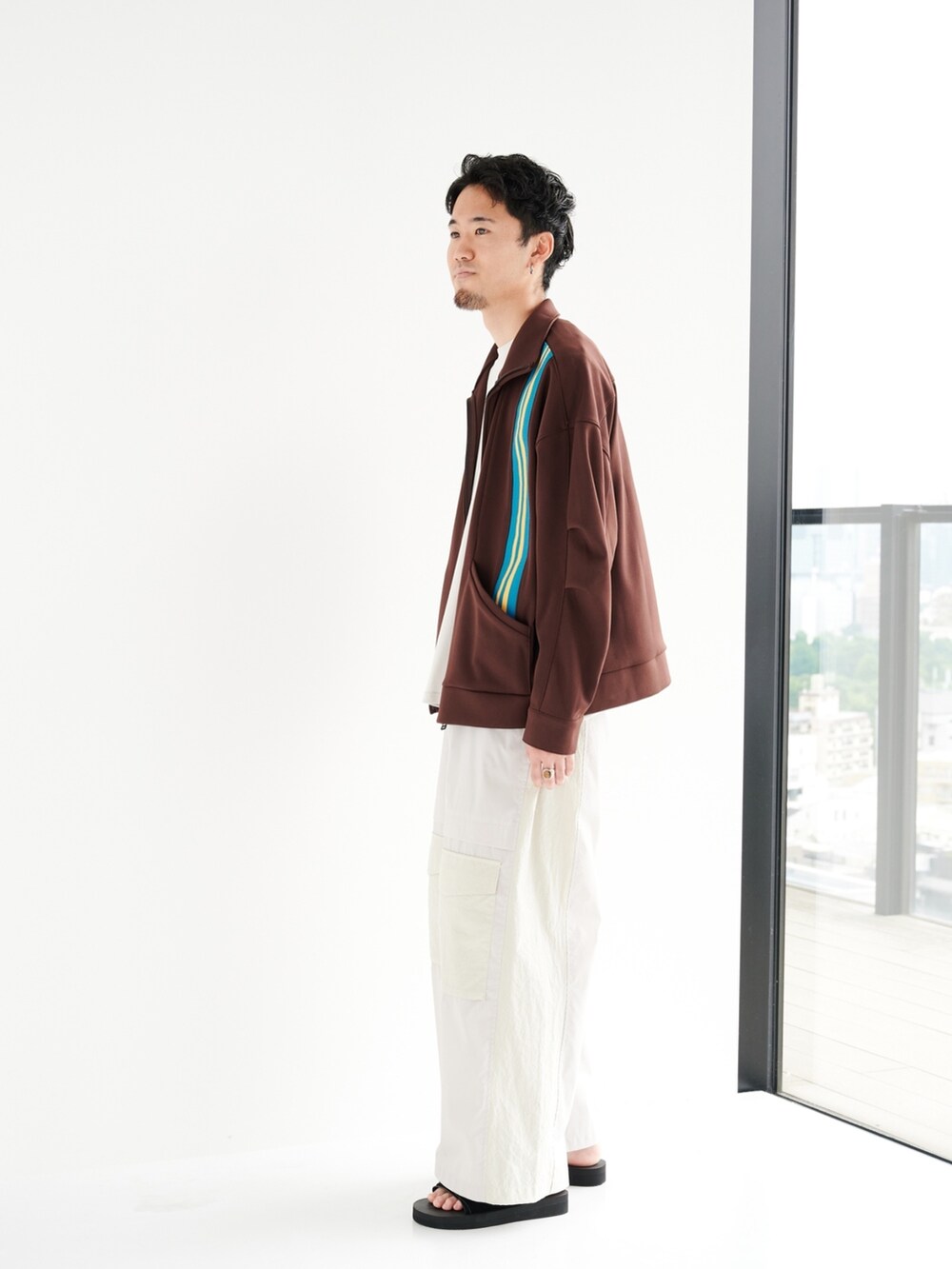 ブラウン系のブルゾン、ベージュ系のカーゴパンツを着用したメンズの夏コーディネートの2枚目の写真