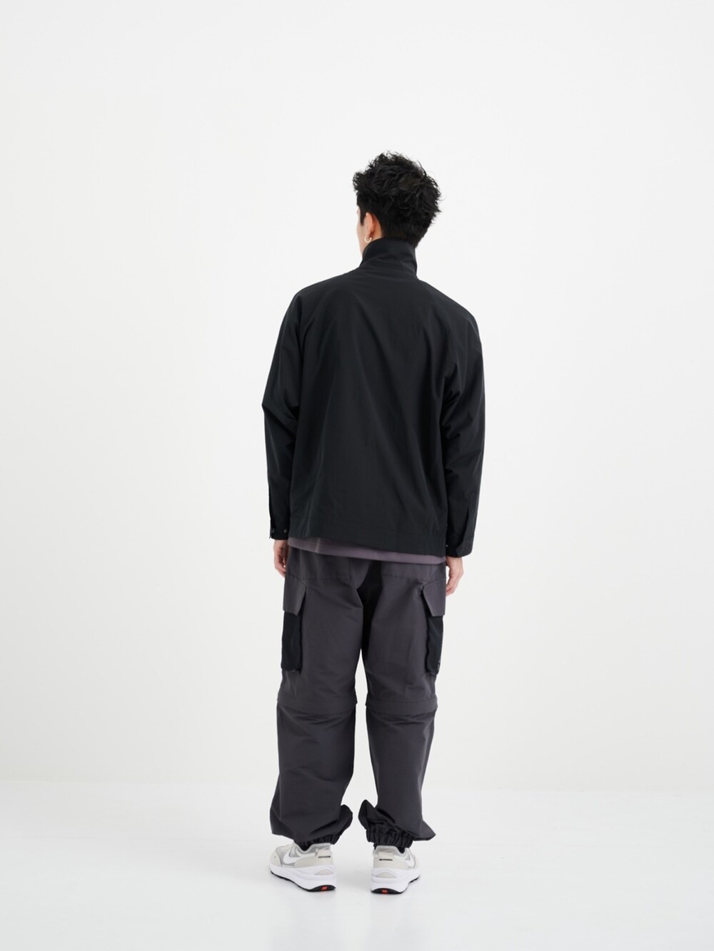 ブラック系のブルゾン、グレー系のカーゴパンツを着用したメンズの夏コーディネートの3枚目の写真