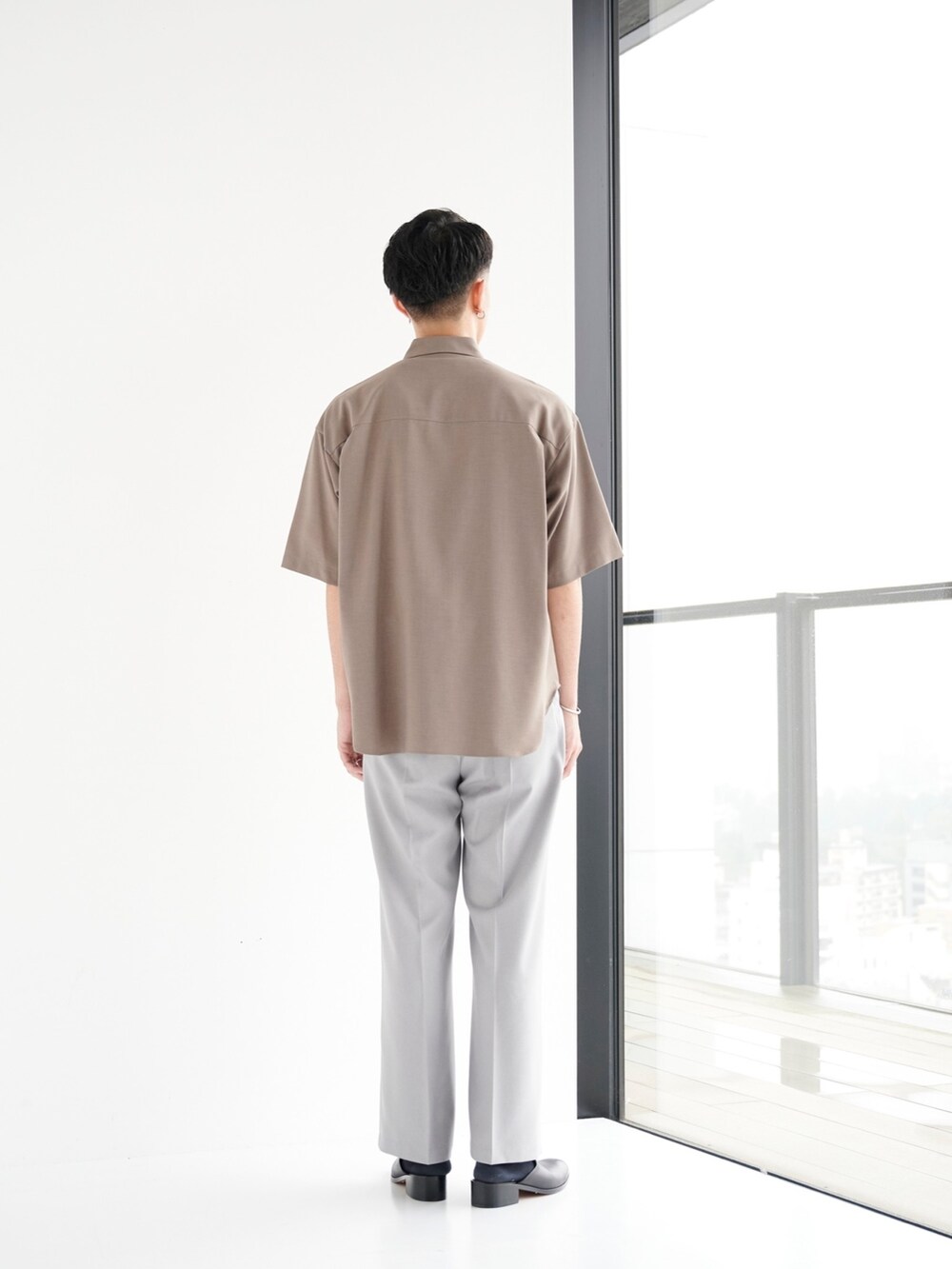 グリーン系のシャツ/ブラウス、グレー系のスラックスを着用したメンズの夏コーディネートの3枚目の写真