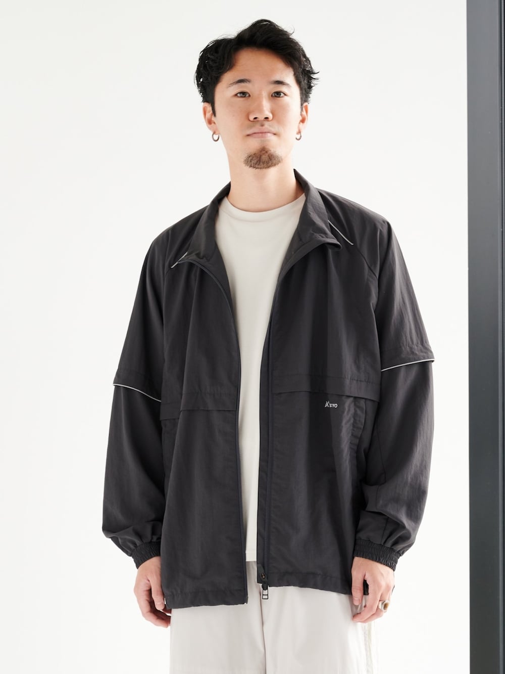 ベージュ系のカーゴパンツ、グレー系のブルゾンを着用したメンズの夏コーディネートの4枚目の写真