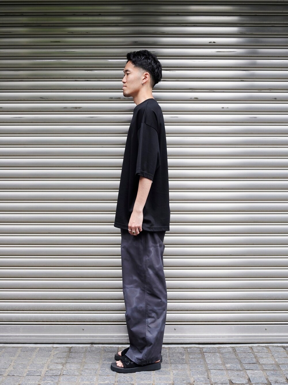 ブラック系のTシャツ/カットソーを着用したメンズの夏コーディネートの2枚目の写真