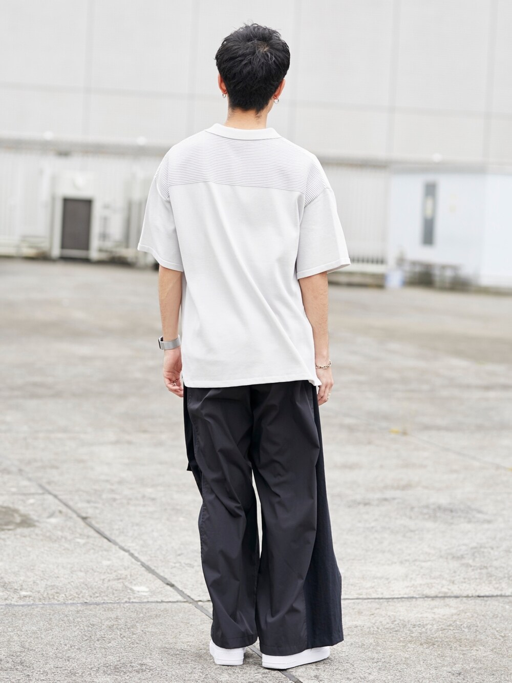 グレー系のポロシャツ、ブラック系のカーゴパンツを着用したメンズの春コーディネートの3枚目の写真