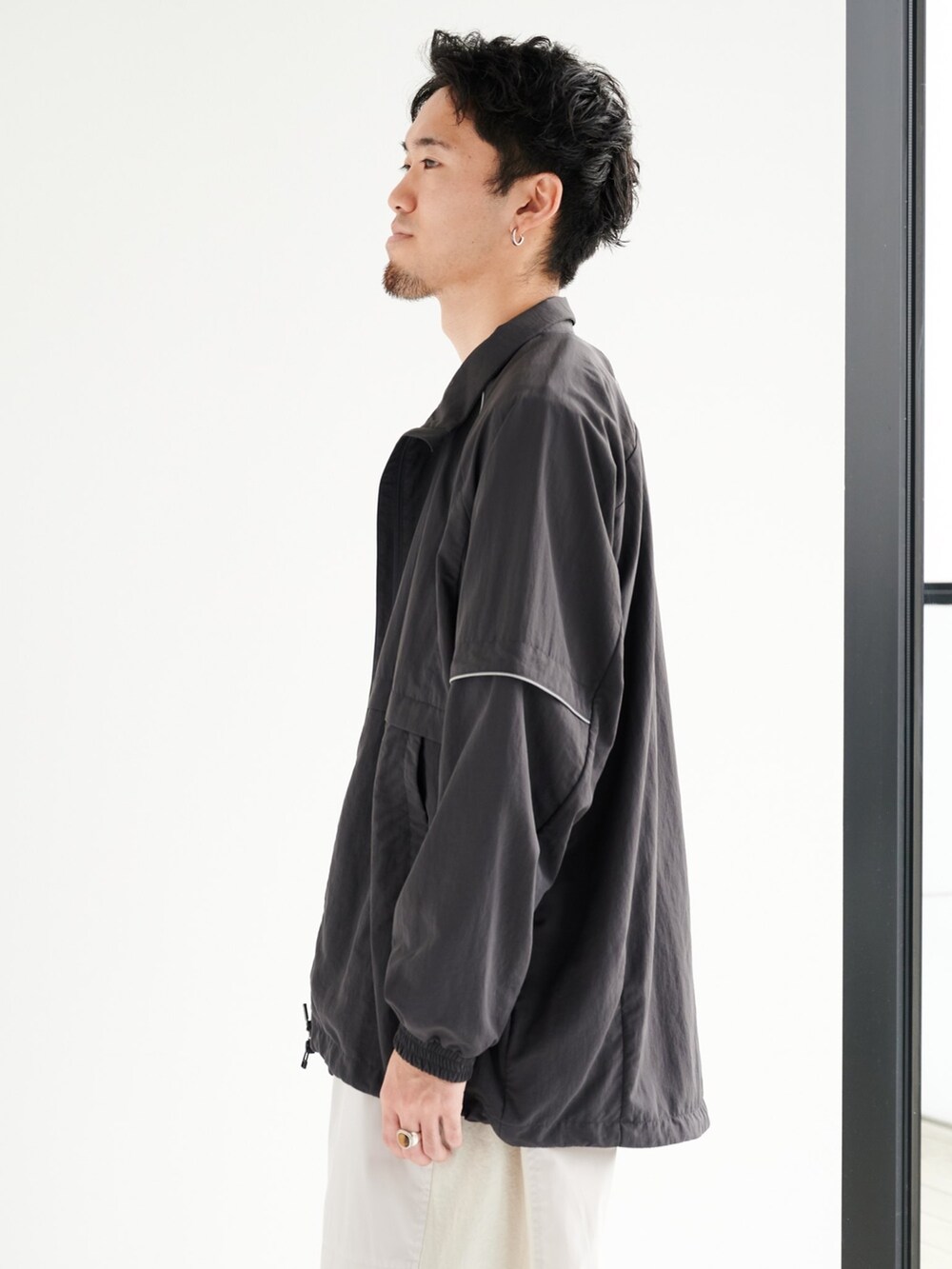 ベージュ系のカーゴパンツ、グレー系のブルゾンを着用したメンズの夏コーディネートの5枚目の写真