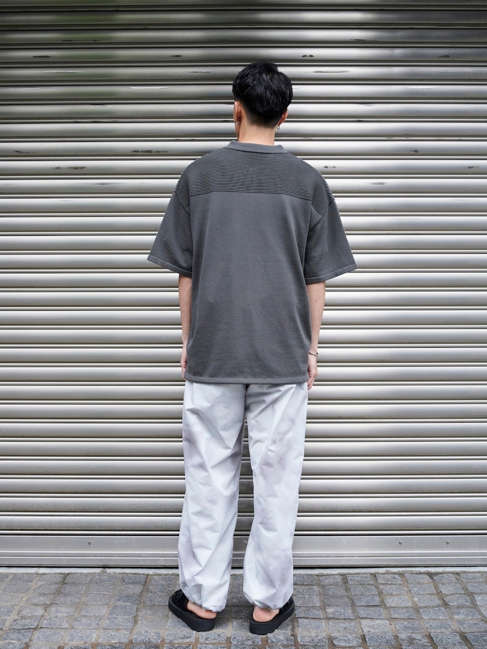 グレー系のポロシャツを着用したメンズの夏コーディネートの3枚目の写真