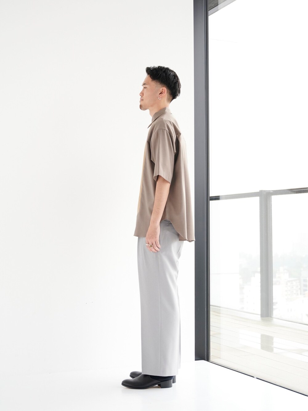 グリーン系のシャツ/ブラウス、グレー系のスラックスを着用したメンズの夏コーディネートの2枚目の写真