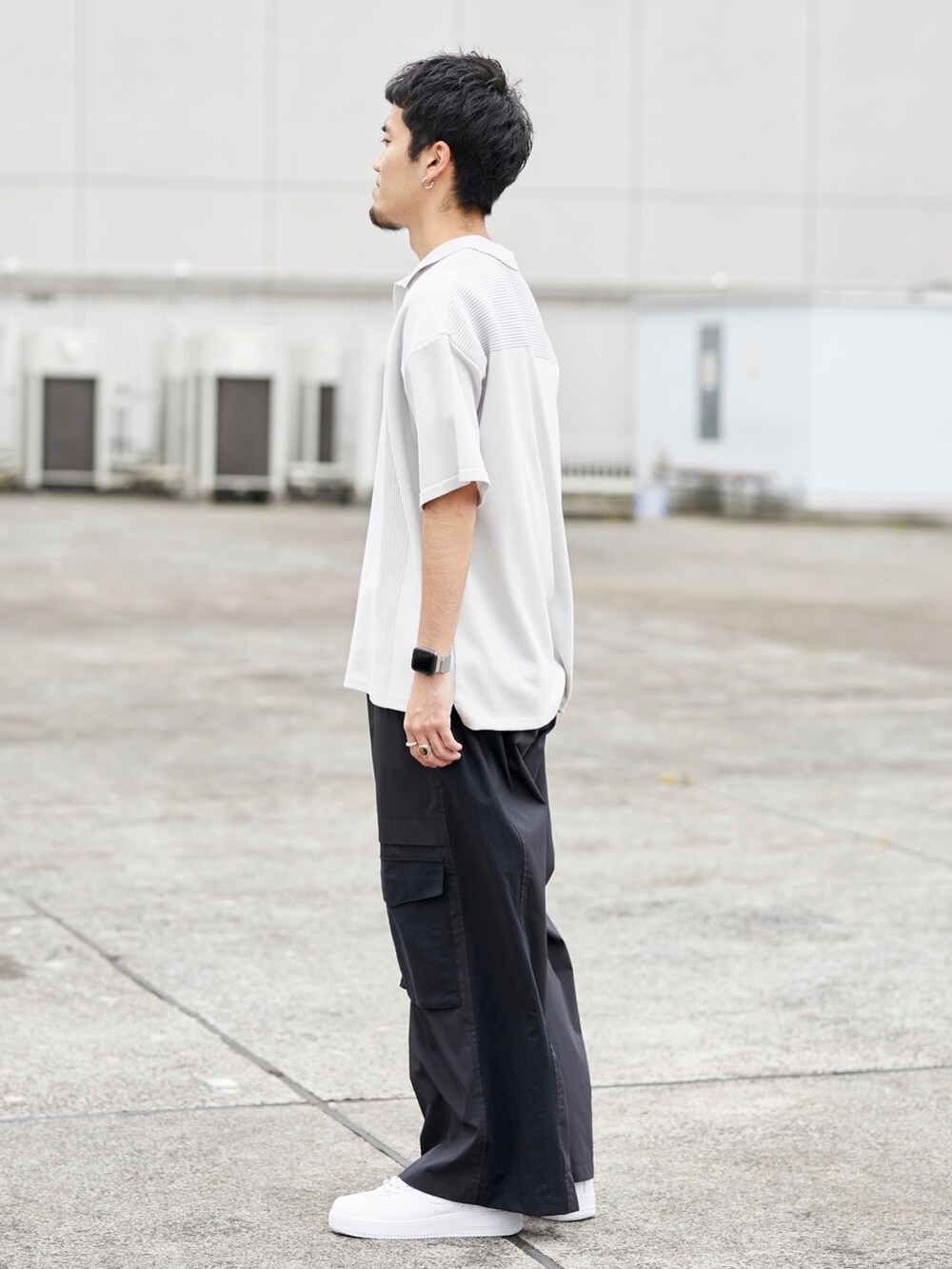 グレー系のポロシャツ、ブラック系のカーゴパンツを着用したメンズの春コーディネートの2枚目の写真