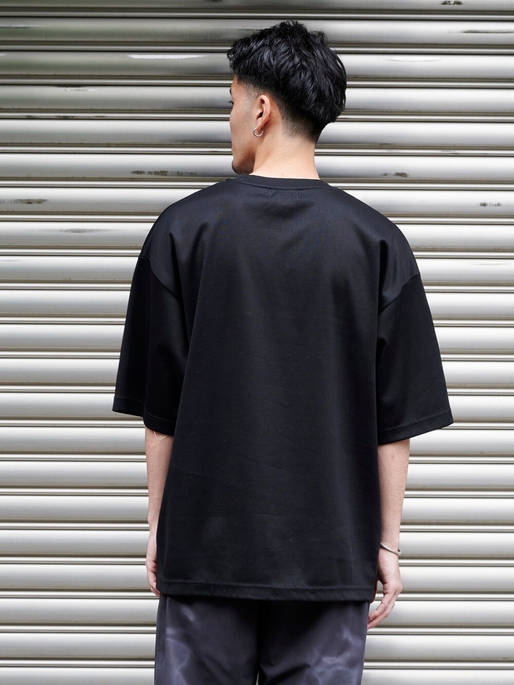 ブラック系のTシャツ/カットソーを着用したメンズの夏コーディネートの6枚目の写真