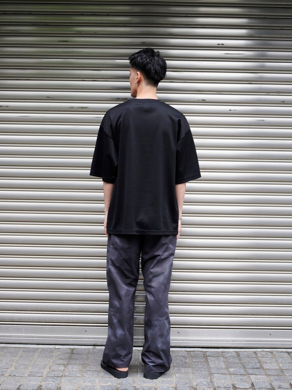 ブラック系のTシャツ/カットソーを着用したメンズの夏コーディネートの3枚目の写真