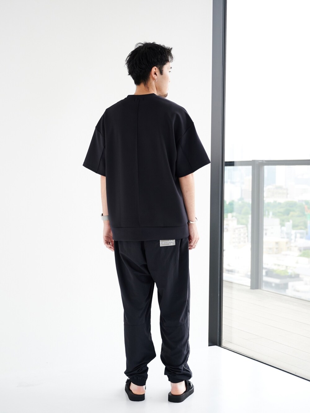 ブラック系のスウェット、ブラック系のカーゴパンツを着用したメンズの夏コーディネートの3枚目の写真