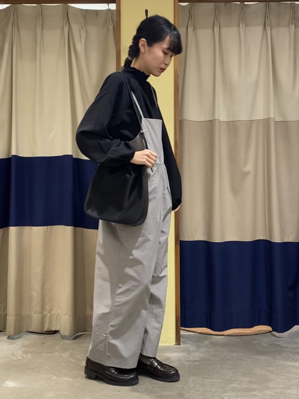 ブラック系のシャツ/ブラウス、ブラック系のTシャツ/カットソー、グレー系のサロペット/オーバーオールを着用したレディースの冬コーディネートの2枚目の写真