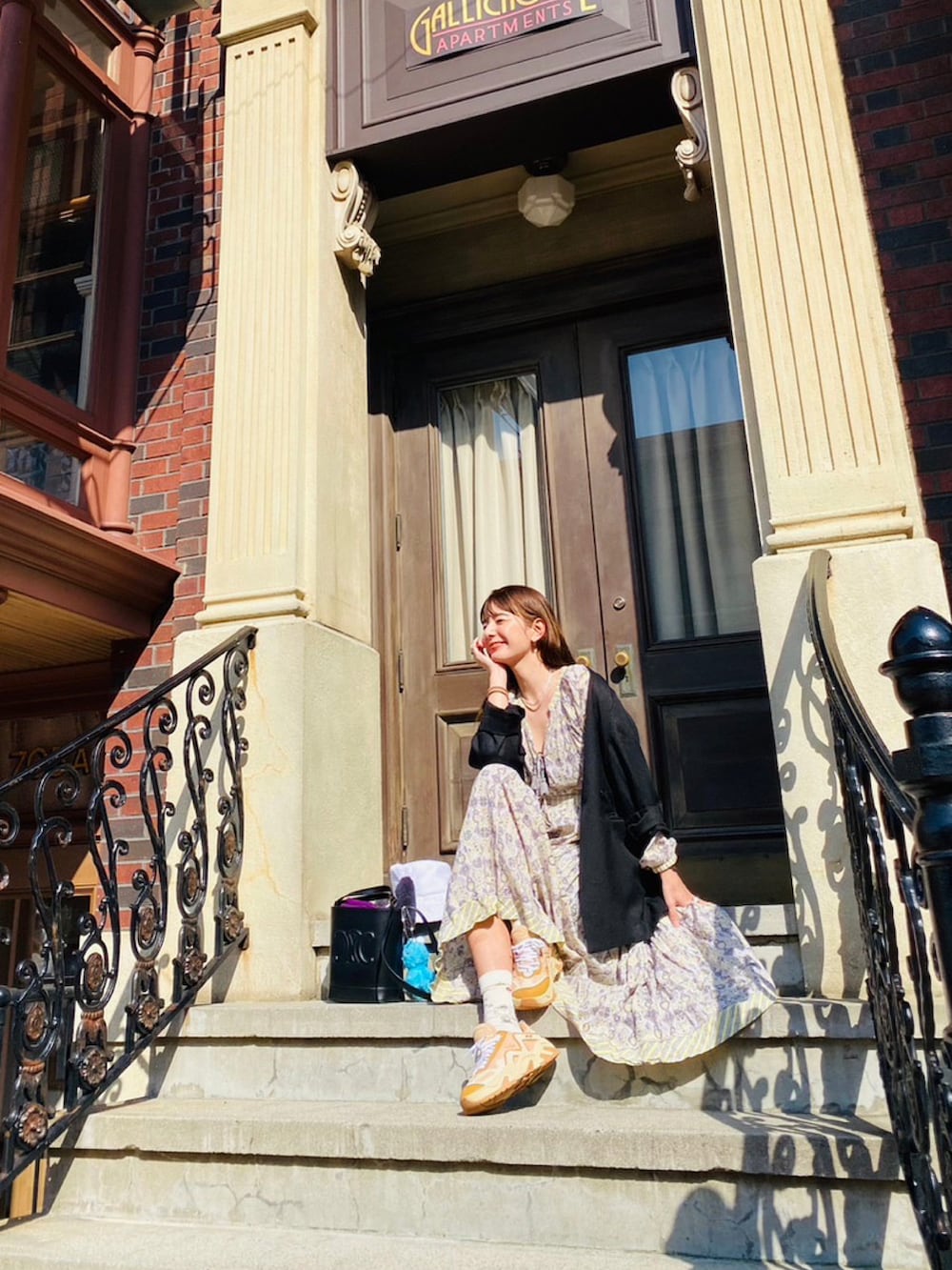 ブラック系のノーカラージャケット、ベージュ系のスニーカーを着用したレディースの春コーディネートの2枚目の写真