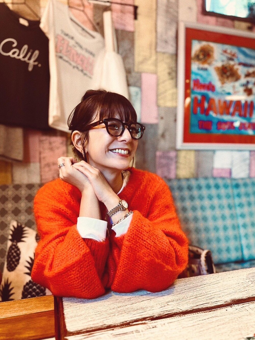 オレンジ系のカーディガン/ボレロ、ブラック系のスラックス、ベージュ系のスニーカーを着用したレディースの秋コーディネートの2枚目の写真