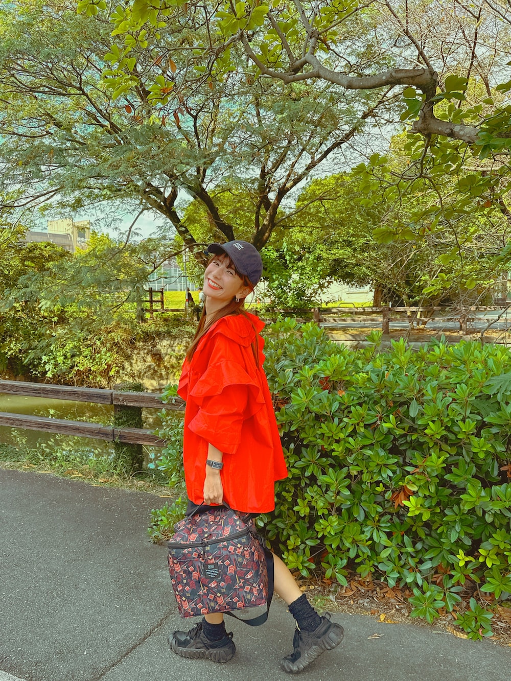 レッド系のシャツ/ブラウス、ブラック系のデニムパンツ、ブラック系のスニーカーを着用したレディースの秋コーディネートの3枚目の写真