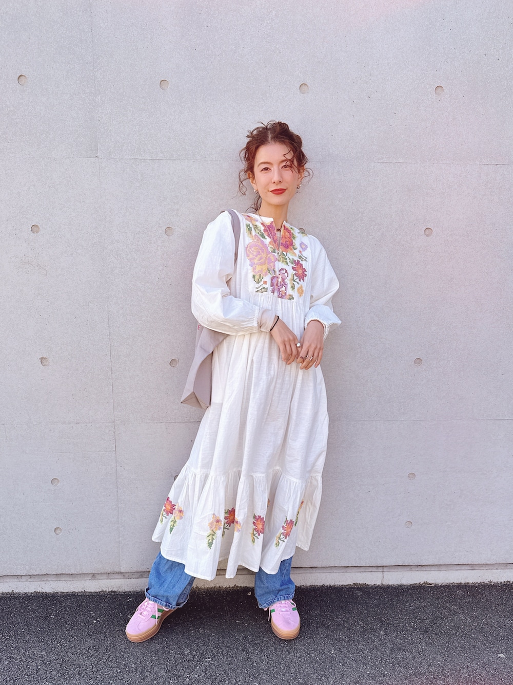 ホワイト系のワンピース、ピンク系のスニーカーを着用したレディースの冬コーディネートの2枚目の写真