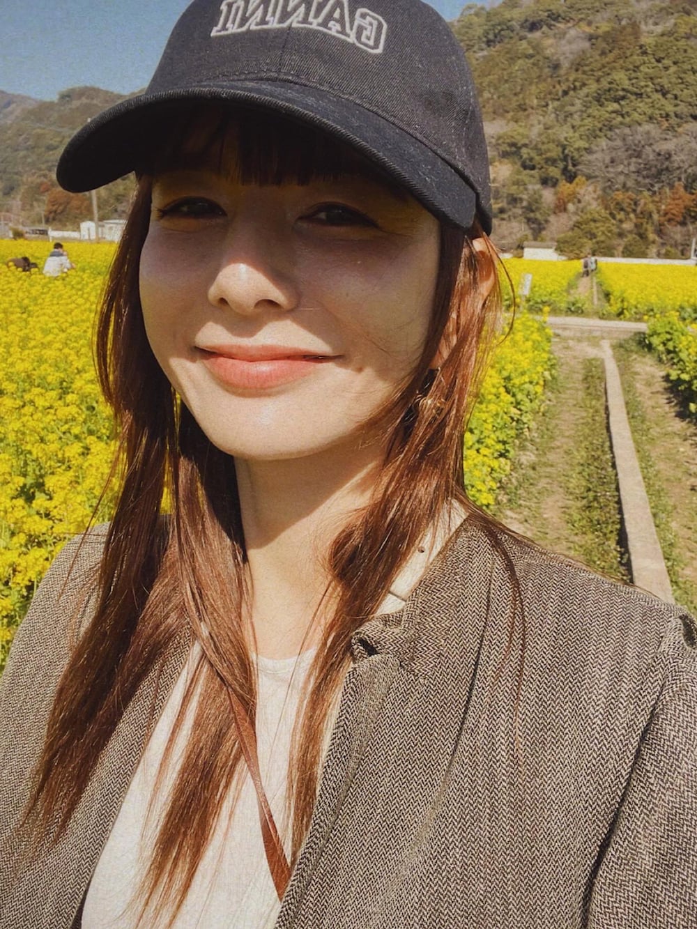 ベージュ系のテーラードジャケット、ホワイト系のショルダーバッグ、ブラック系のその他パンツを着用したレディースの冬コーディネートの2枚目の写真