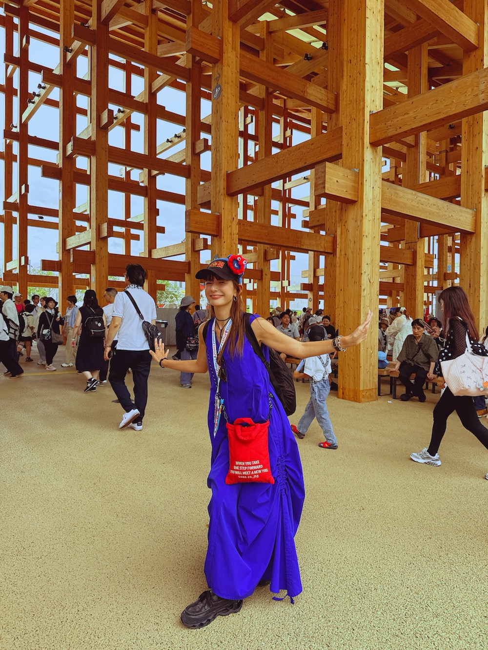 ブルー系のワンピース、レッド系のショルダーバッグ、ブラック系のスニーカーを着用したレディースの秋コーディネートの2枚目の写真