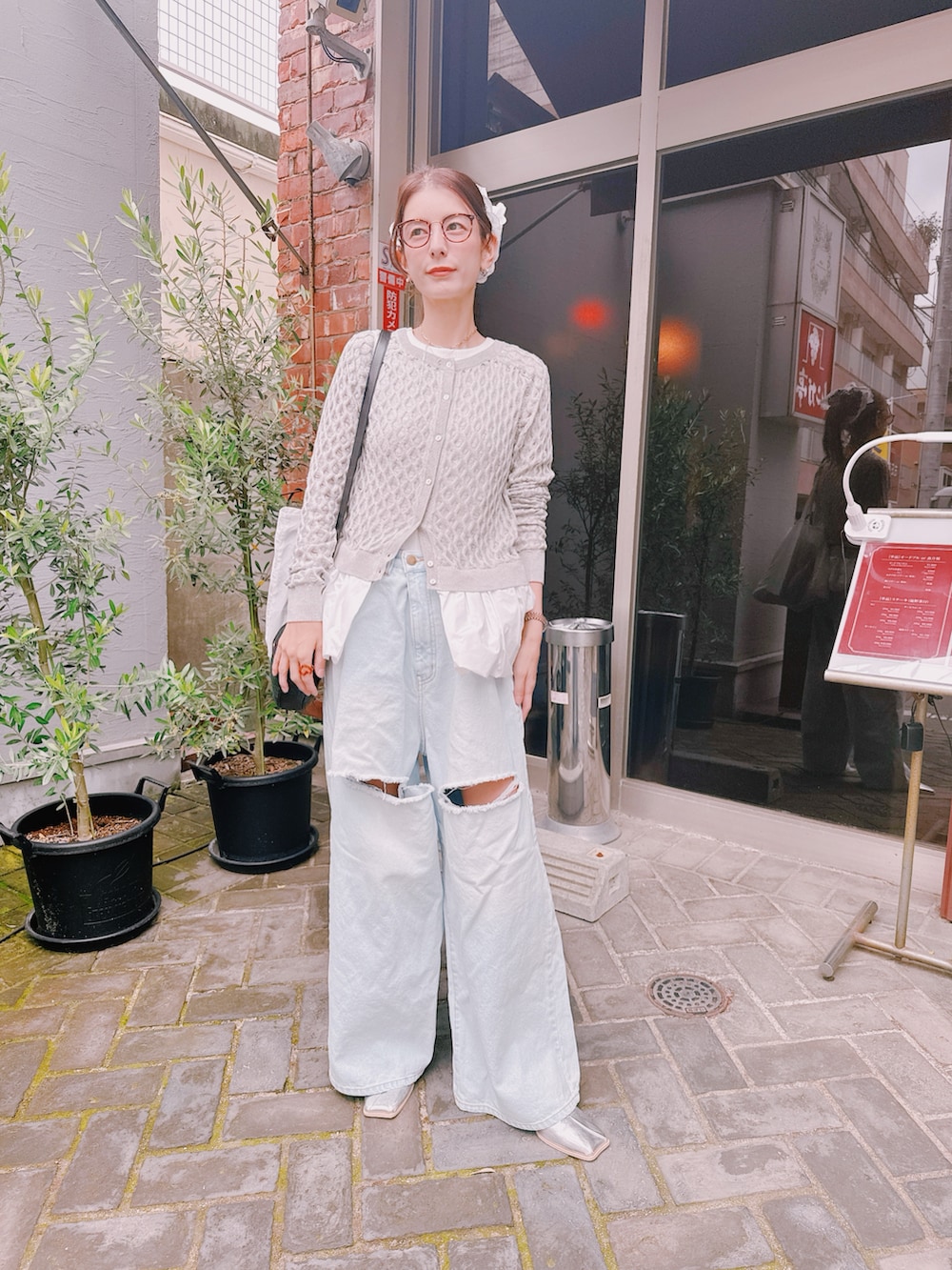 ブルー系のデニムパンツ、グレー系のカーディガン/ボレロ、シルバー系のローファーを着用したレディースの春コーディネートの2枚目の写真