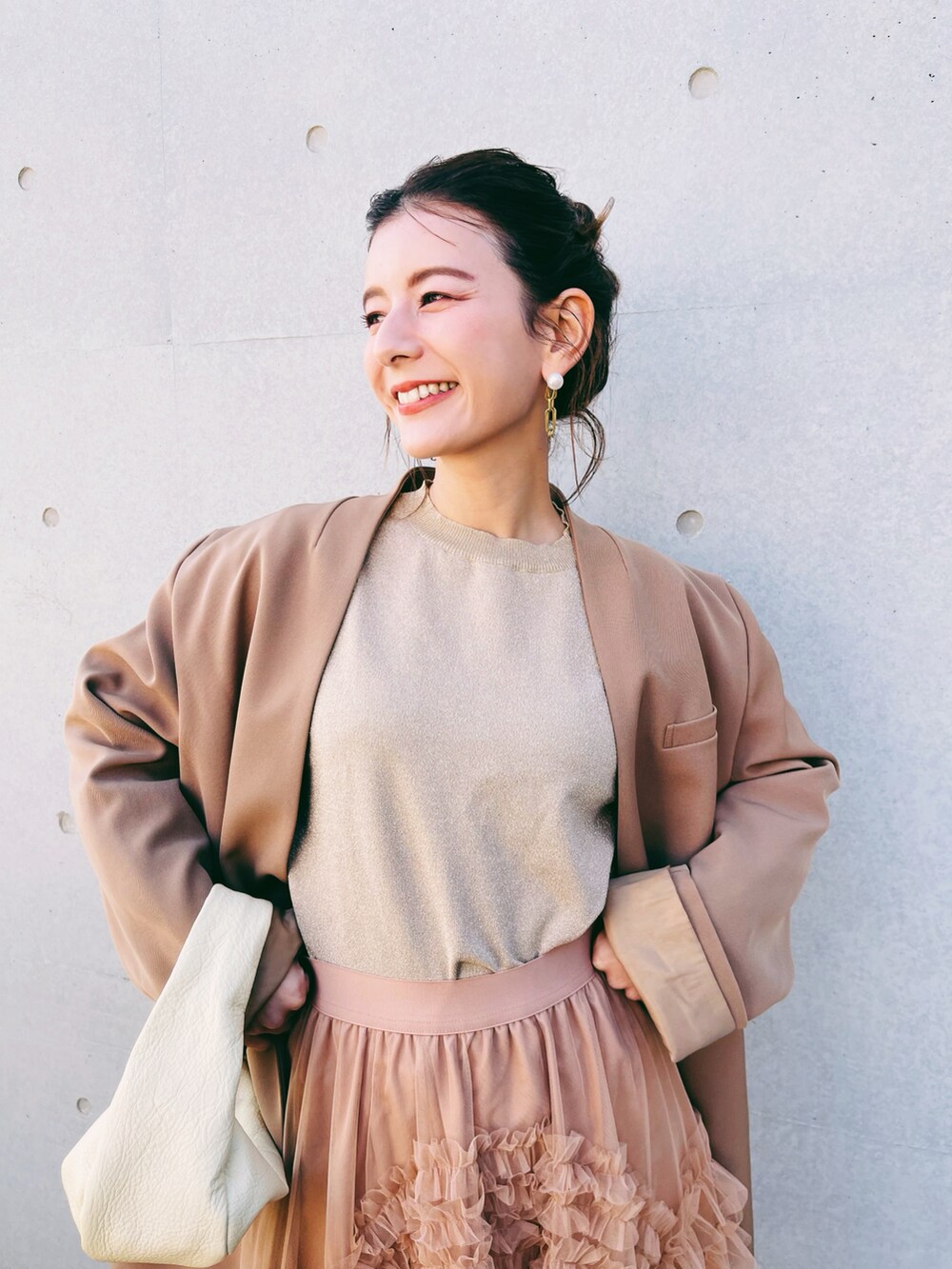 ブラック系のスカート、ベージュ系のハンドバッグ、ベージュ系のノーカラージャケットを着用したレディースの秋コーディネートの4枚目の写真