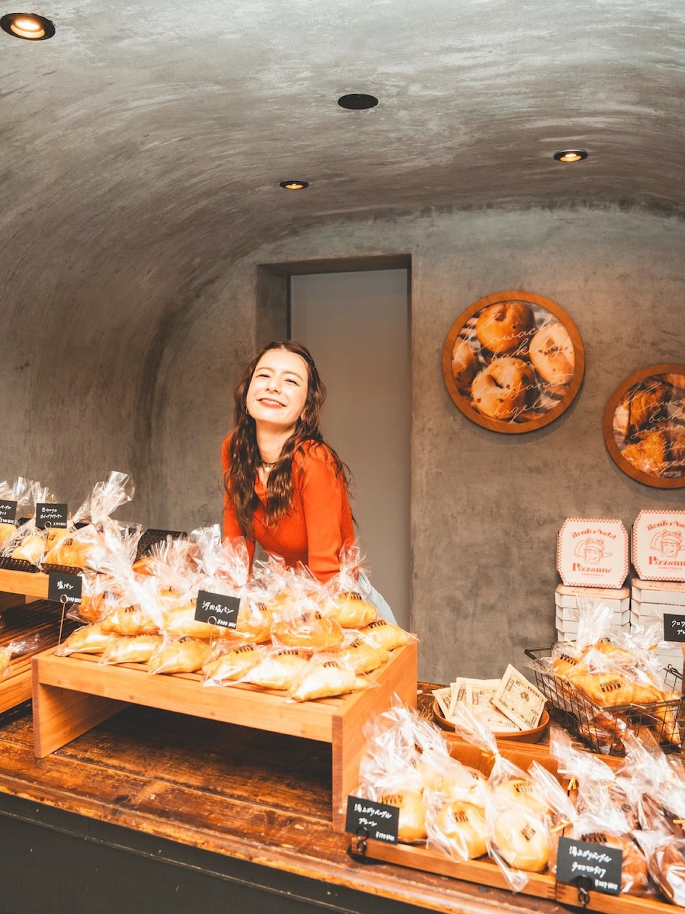 オレンジ系のTシャツ/カットソー、ブルー系のデニムパンツを着用したレディースの春コーディネートの2枚目の写真