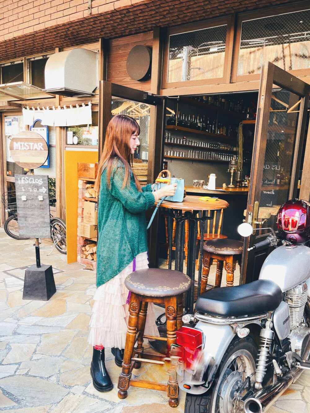 グリーン系のニット/セーター、ベージュ系のスカート、ブラック系のシューズを着用したレディースの秋コーディネートの2枚目の写真