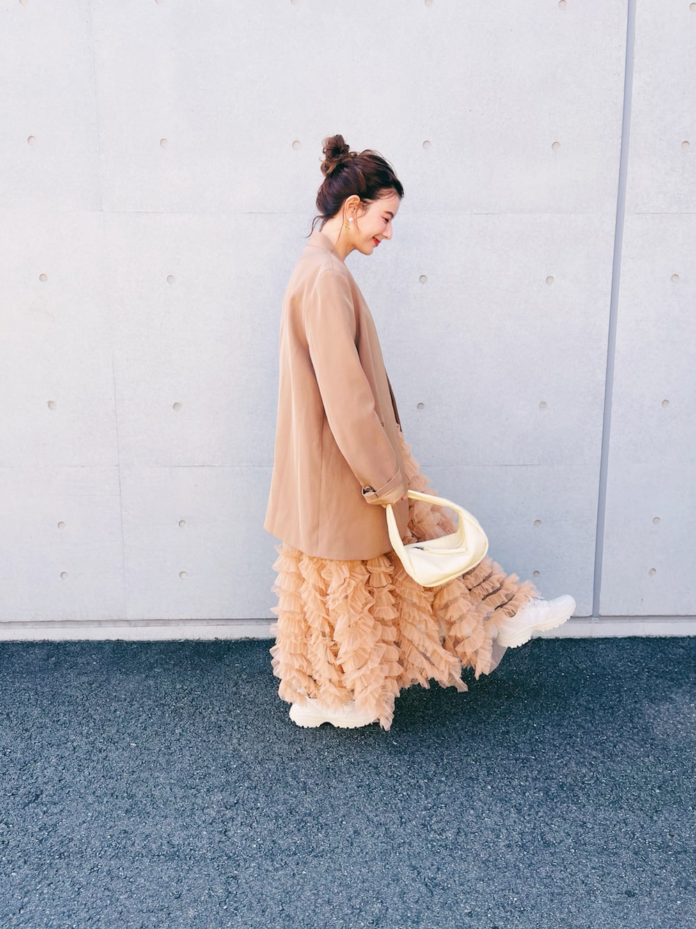 ブラック系のスカート、ベージュ系のハンドバッグ、ベージュ系のノーカラージャケットを着用したレディースの秋コーディネートの2枚目の写真