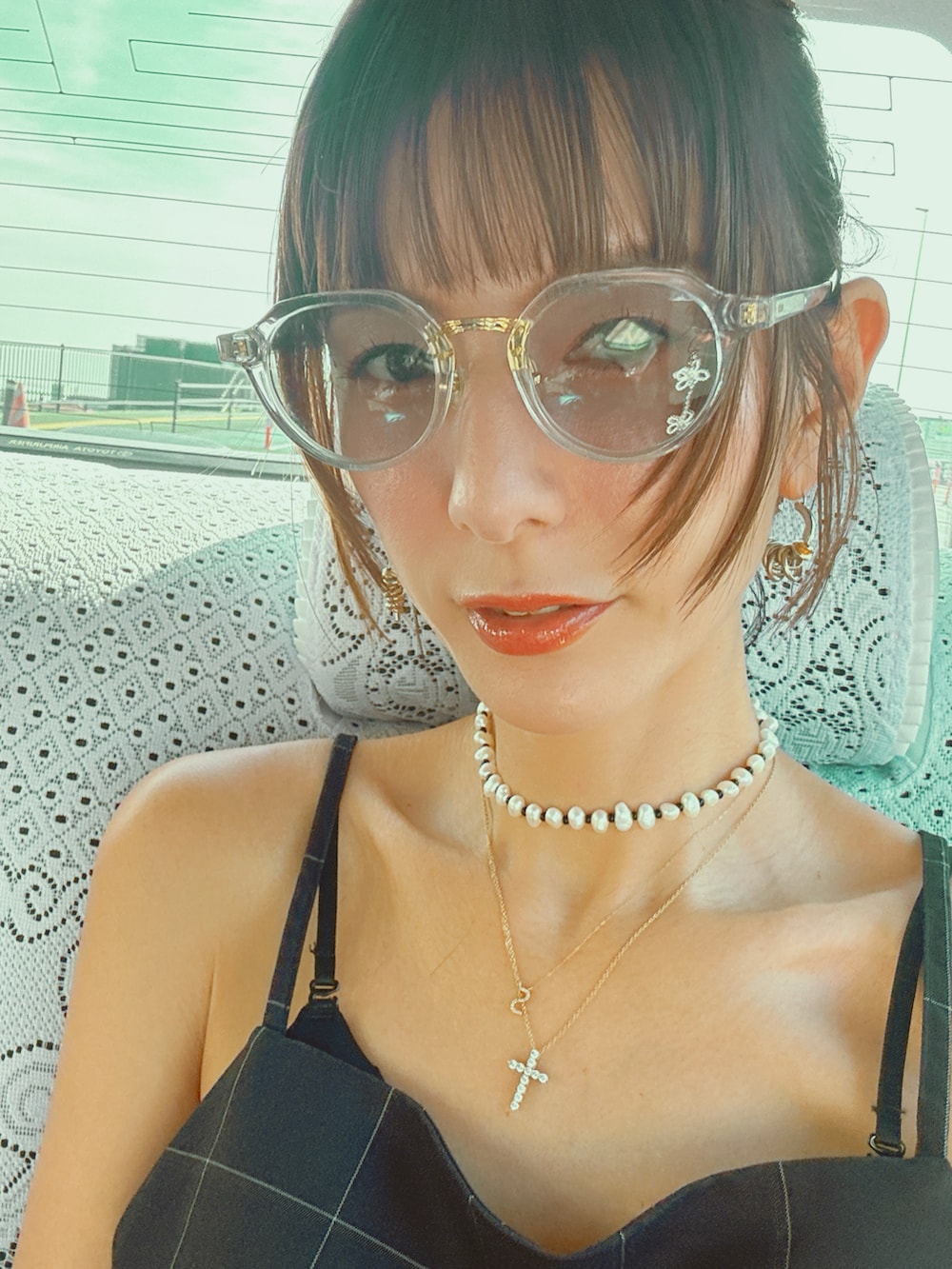 ベージュ系のバッグ、ブラック系のキャミソール、ブラック系のスラックスを着用したレディースの秋コーディネートの3枚目の写真