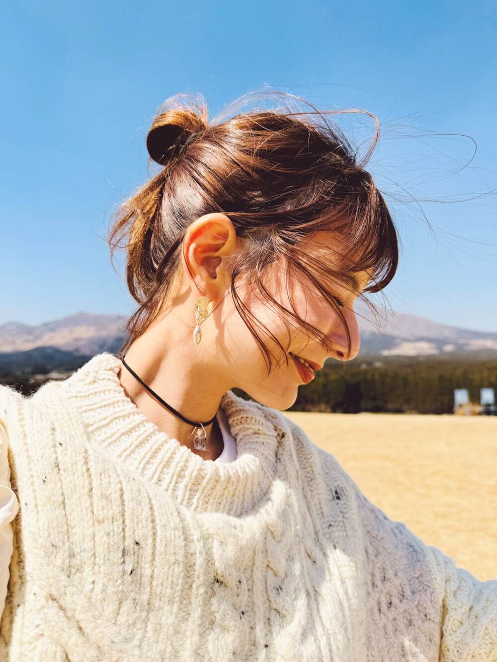 ベージュ系のニット/セーター、ベージュ系のスカート、ベージュ系のスニーカーを着用したレディースの春コーディネートの2枚目の写真