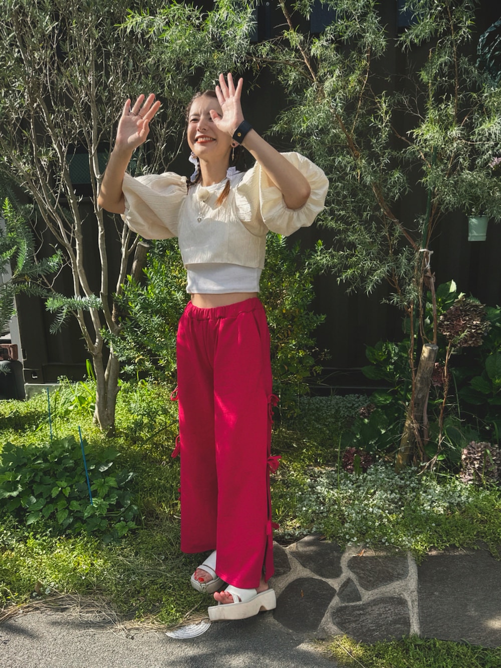 ピンク系のパンツ、ホワイト系のサンダル、ホワイト系のシャツ/ブラウスを着用したレディースの夏コーディネートの2枚目の写真