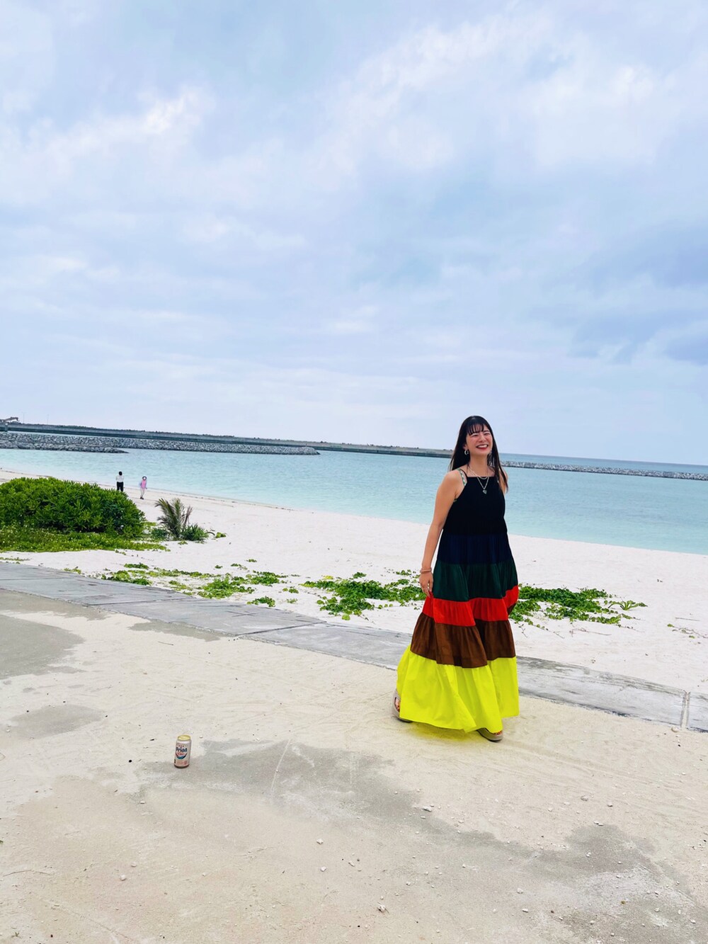 イエロー系のワンピース、ベージュ系のサンダルを着用したレディースの春コーディネートの2枚目の写真